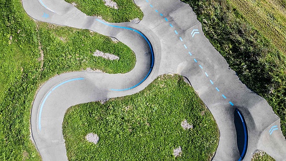 Detailansicht Pumptrack Wiggensbach mit blauen Markierungen und Asphaltkurven