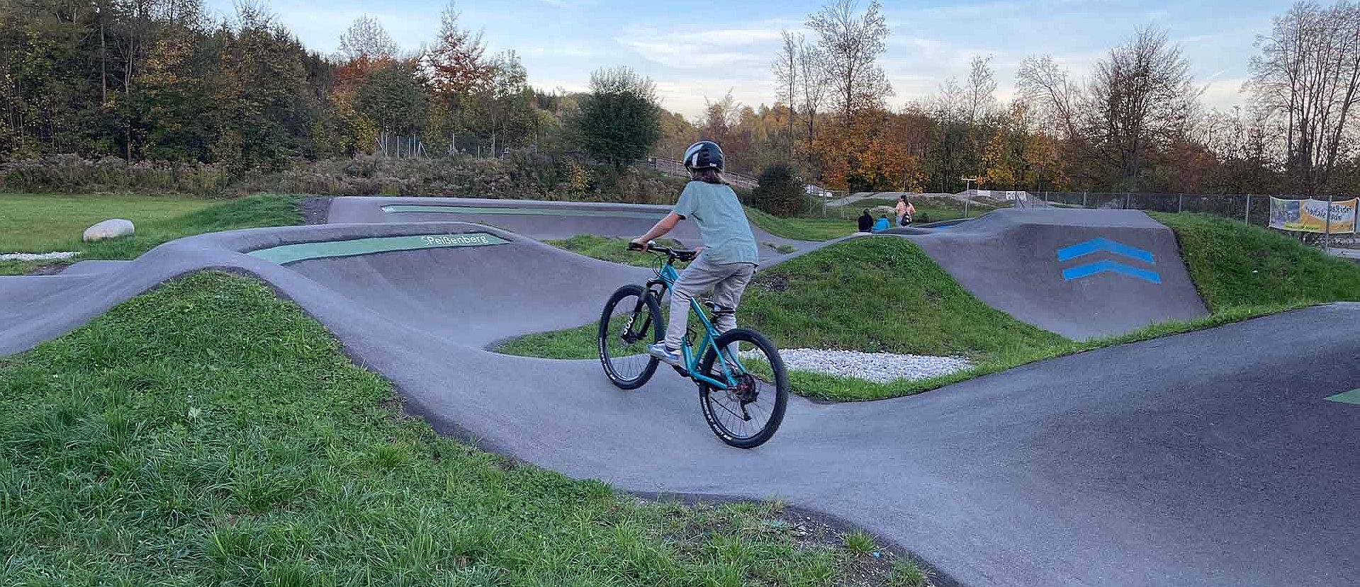 Child riding through berm at pump track Peißenberg
