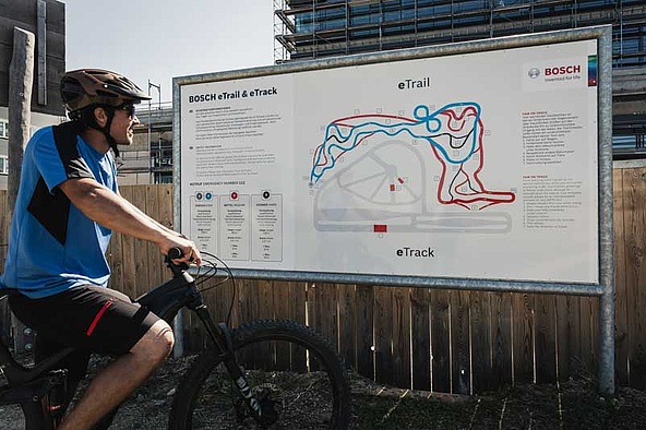 Biker stands in front of overview board of eBike trail