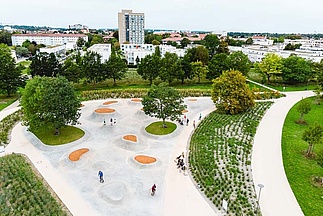 Drone image of skate park with green areas and people on the site