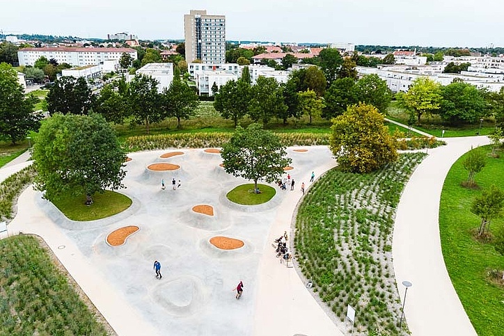 Drohnenbild von Skatepark mit Grünflächern und Menschen auf dem Gelände