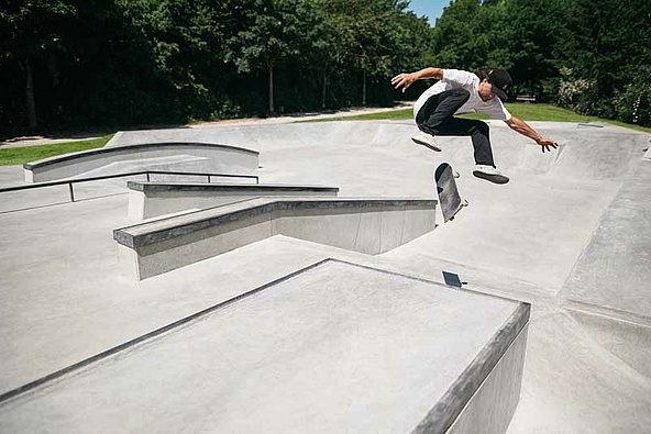 Skateboarder macht Trick in Ortbeton Skatepark
