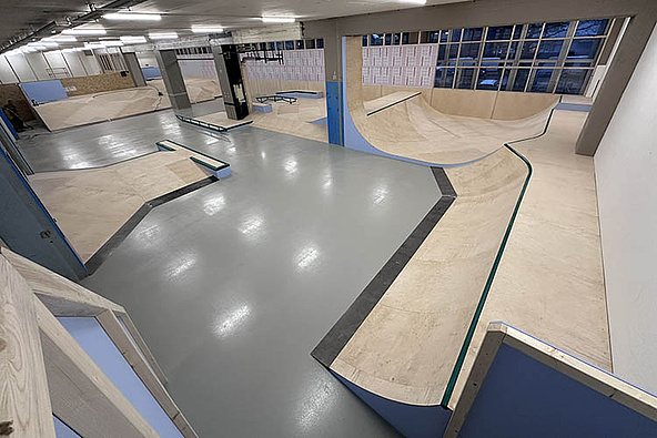 Weitwinkelaufnahme der Skatehalle Bern mit mehreren Rampen
