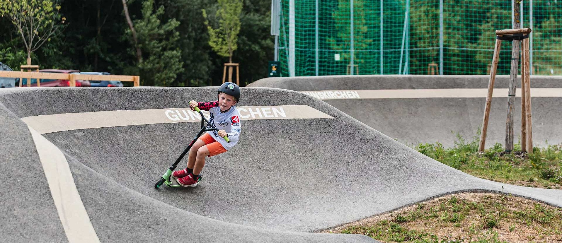 [Translate to Französisch:] Child with scooter rides in pump track