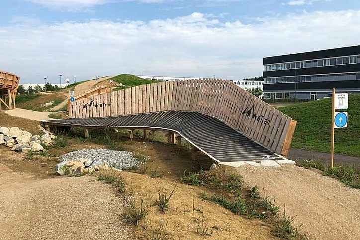 Holzhindernis Brücke auf E-Bike-Trail vor Gebäude