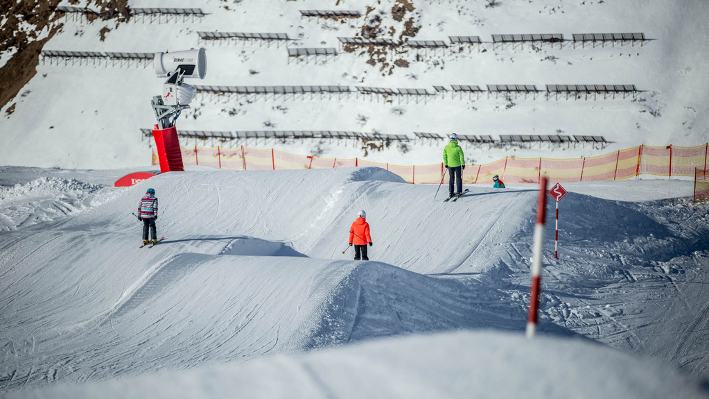 Drei Skifahrer fahren über Wellen