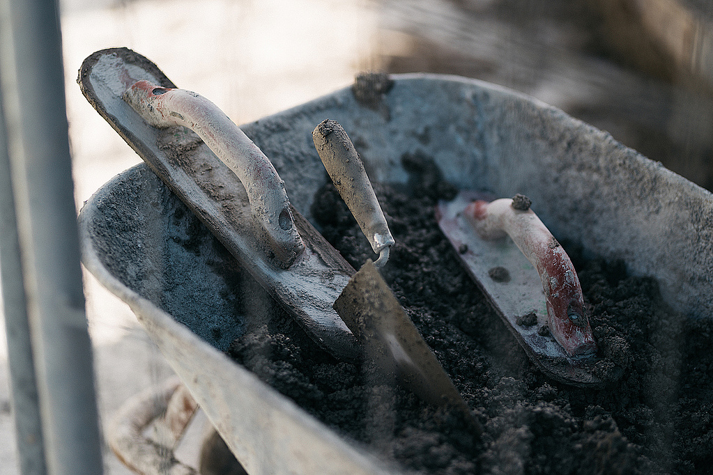 Wheelbarrow with spatula and concrete