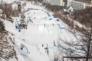 Slopestyle Pyeongchang mit Sessellift und Hochhäusern im Hintergrund