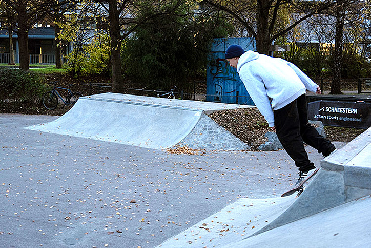 Skateboarder fährt die Bank im Skatepark Memmingen hoch