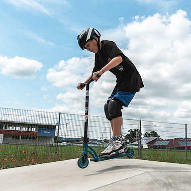 Kind fährt mit Scooter im Scooterpark