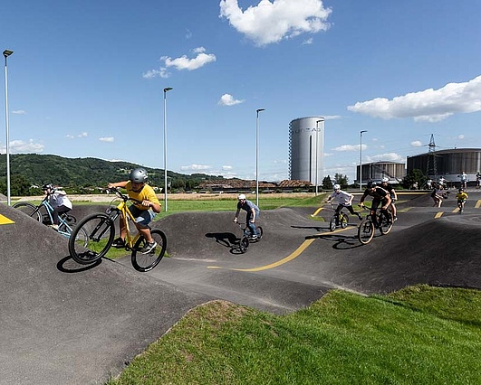 Group of teenagers ride on the pump track