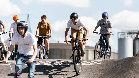 Group of teenagers riding on the pump track