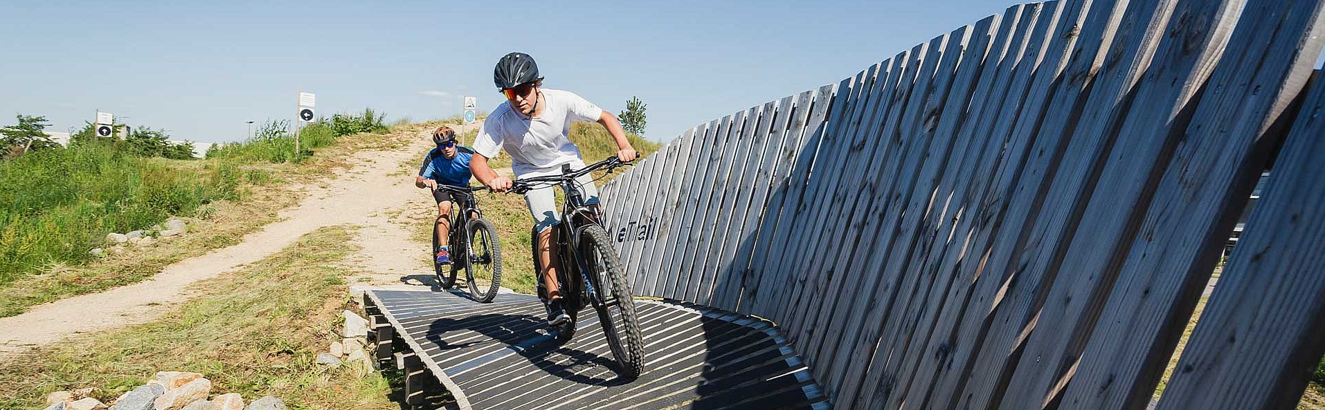 E-bike trail with artificial curve and two e-bikers