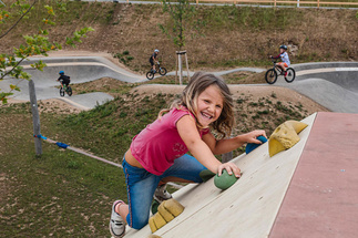 Mädchen klettert an Kletterwand hoch