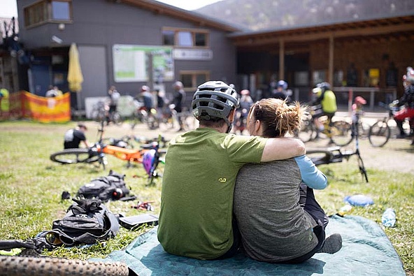 Couple in front of many bikes in the lounge area of the trail center