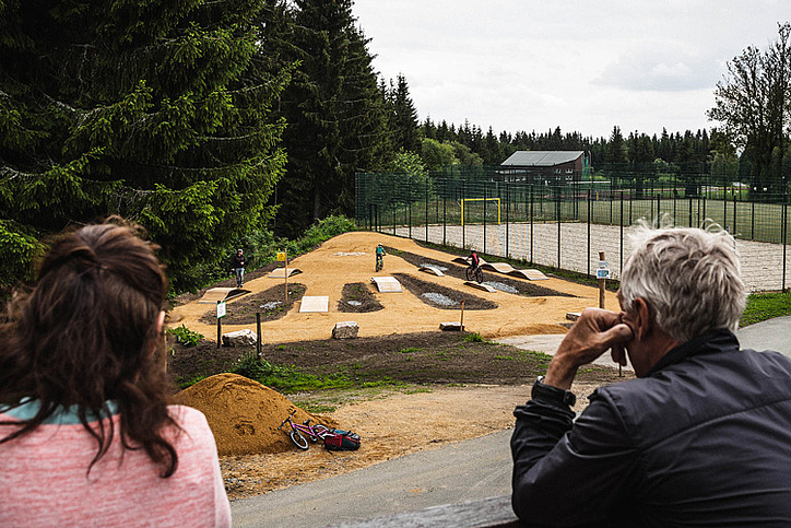 Pumptrack im MTB-Park Rabenberg mit Zuschauern und Fahrern