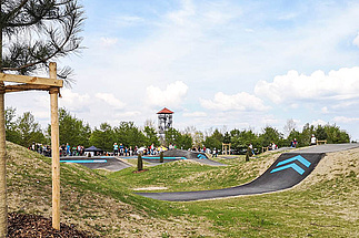Pump track Pocking with visitors and observation tower in the background