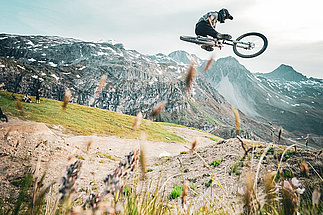 VTTiste effectuant un tabletop devant un paysage alpin sur la piste  Fresse Tagada  du Bikepark Tignes.