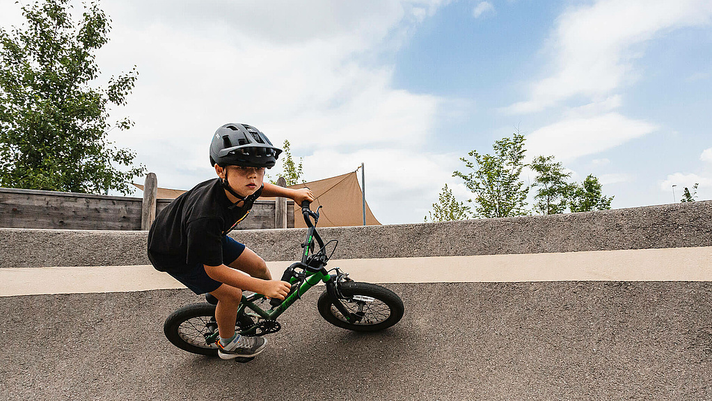 Junge fährt mit seinem Rad in einer Kurve im Pumptrack Gunskirchen