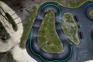 Vue aérienne du Pumptrack Audenge avec des pistes en asphalte sinueuses dans la forêt