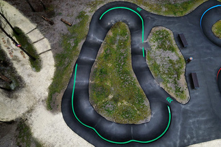 Luftaufnahme des Pumptrack Audenge mit geschwungenen Asphaltbahnen im Waldgebiet