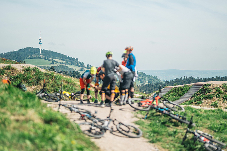 Mountain bike group pauses in front of mountain panorama