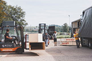Boxes are carried across the yard with forklifts