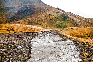 Frisch geformte Anliegerkurve aus Lehm auf der Hochalpin‑Strecke im Bikepark Tignes.