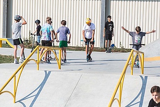 Young people with scooters in the skate park