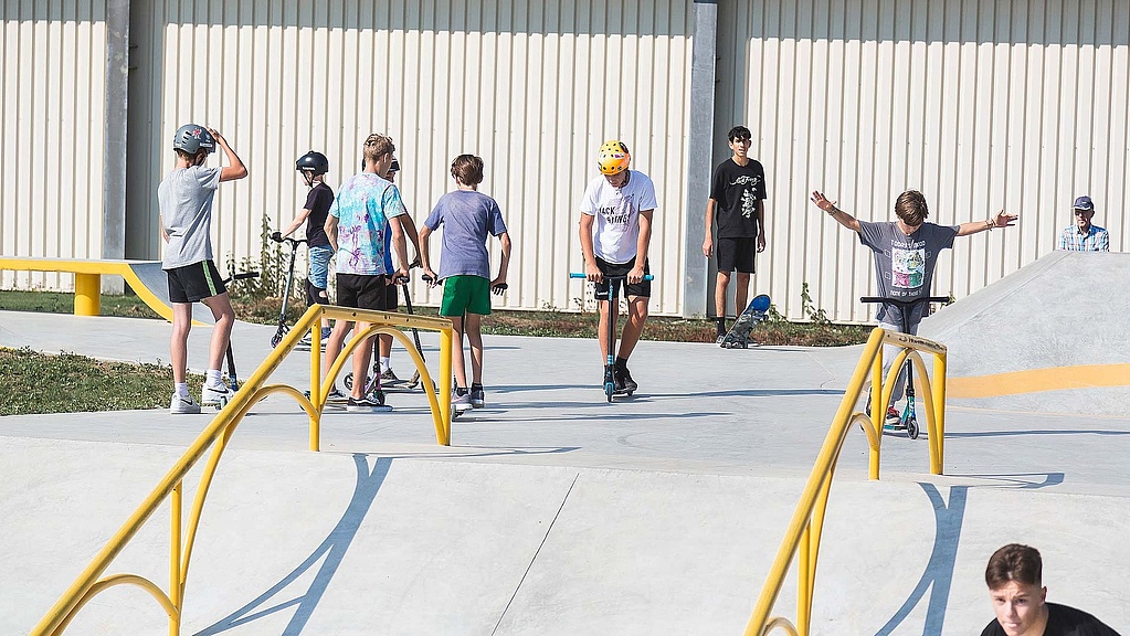 Jugendliche mit Scootern im Skatepark