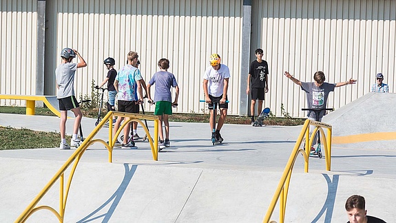 Young people with scooters in the skate park