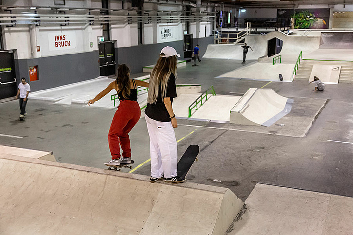 Two girls with skateboards in the skate hall Innsbruck
