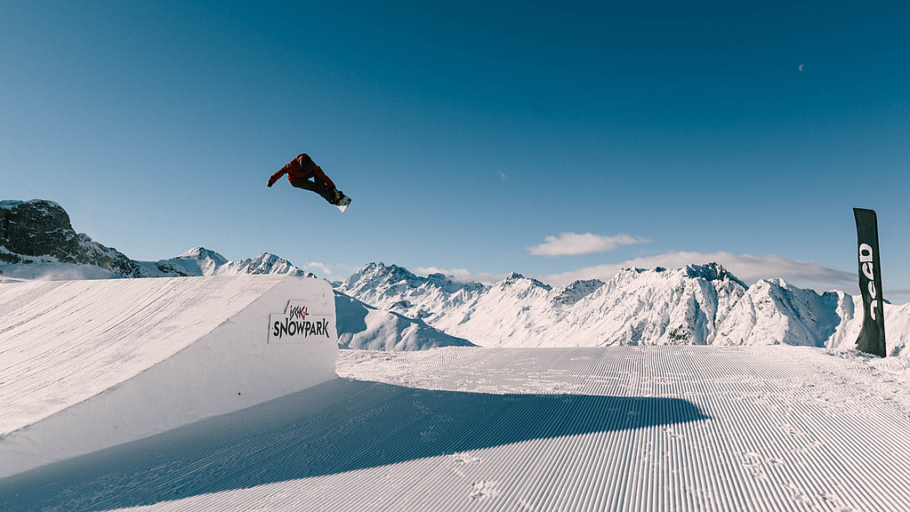 Snowboarder fliegt in der Luft im Snowpark Ischgl