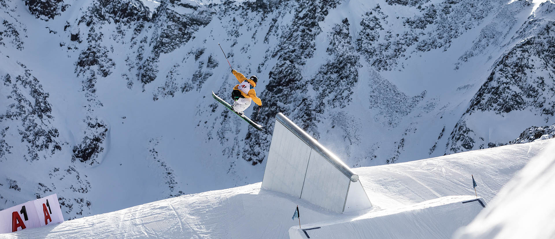 Skifahrer ist nach Sprung in der Luft vor Bergpanorama