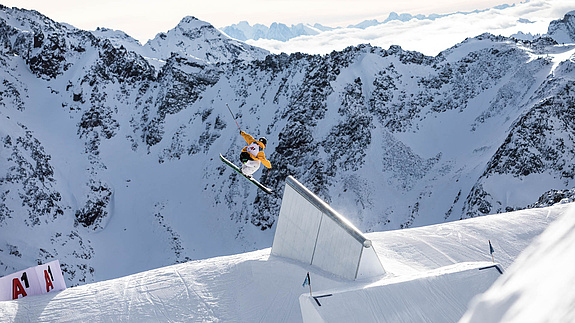 Skifahrer ist nach Sprung in der Luft vor Bergpanorama