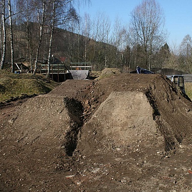 Dirt park with two tables and blue sky