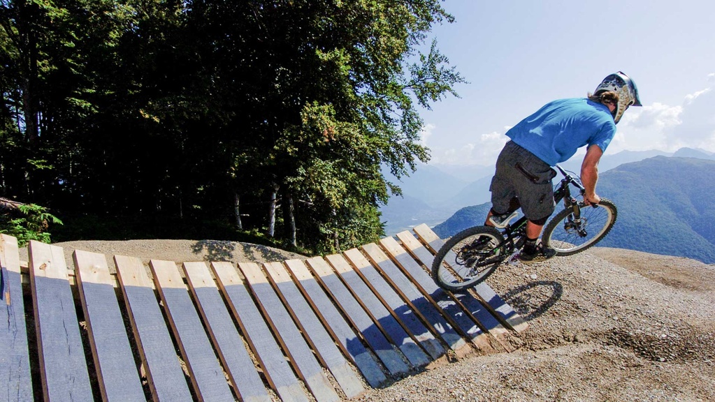 Biker springt von North Shore Element aus dem Wald