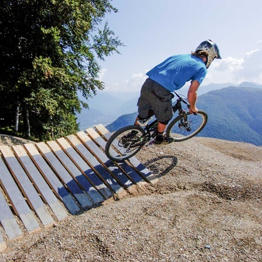 Biker springt von North Shore Element aus dem Wald