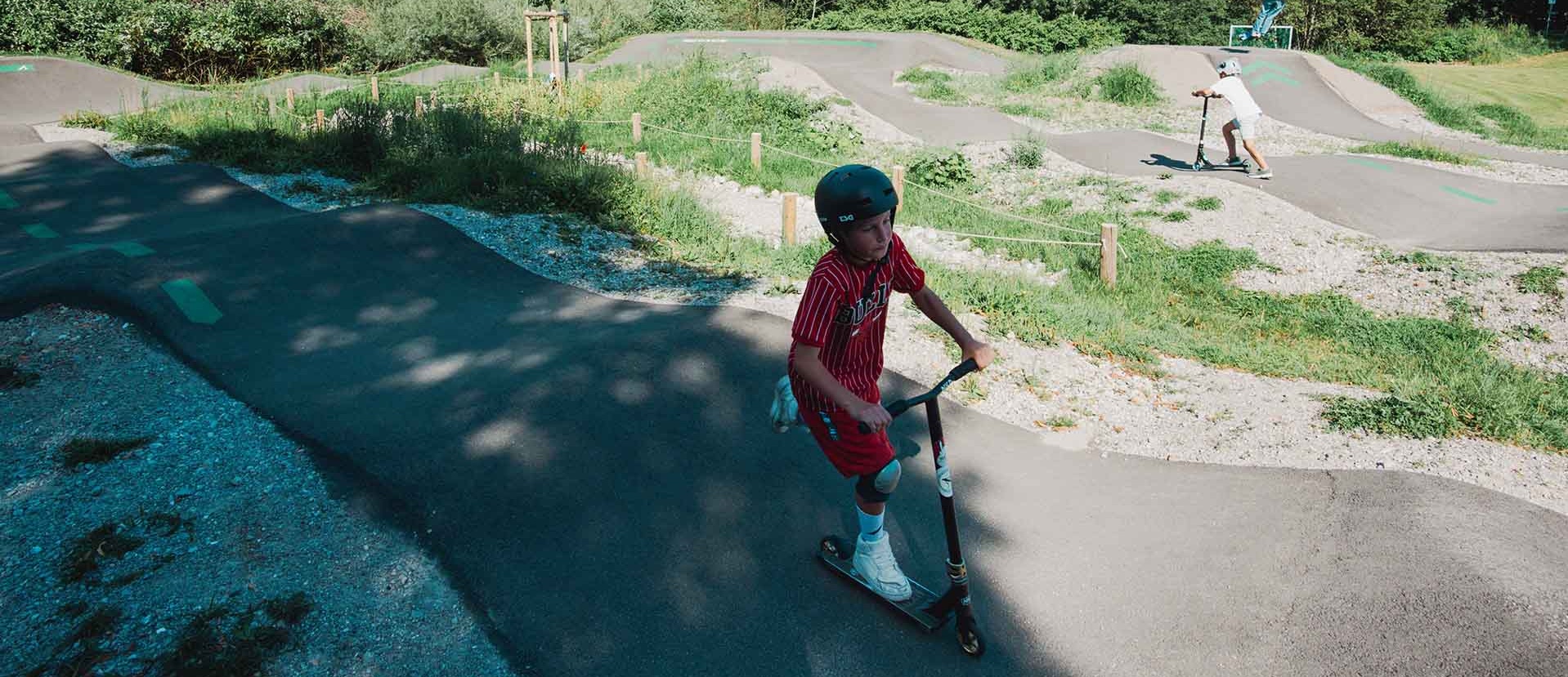 Pump track Immenstadt surrounded by nature with scooter rider