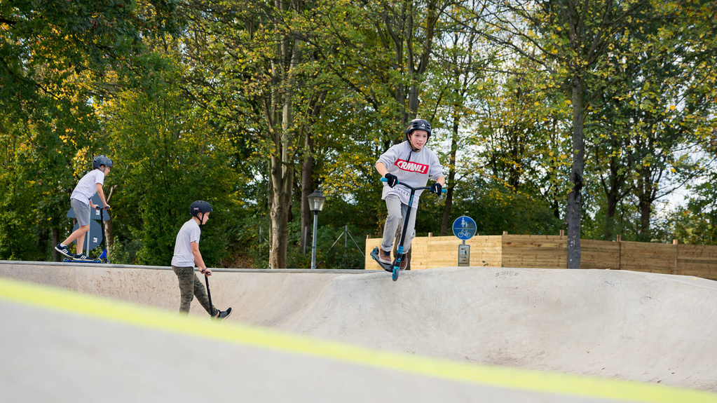 Boy on scooter rides in skate park Hennef