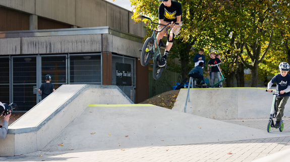 Several boys in skate park Hennef with bike and scooter