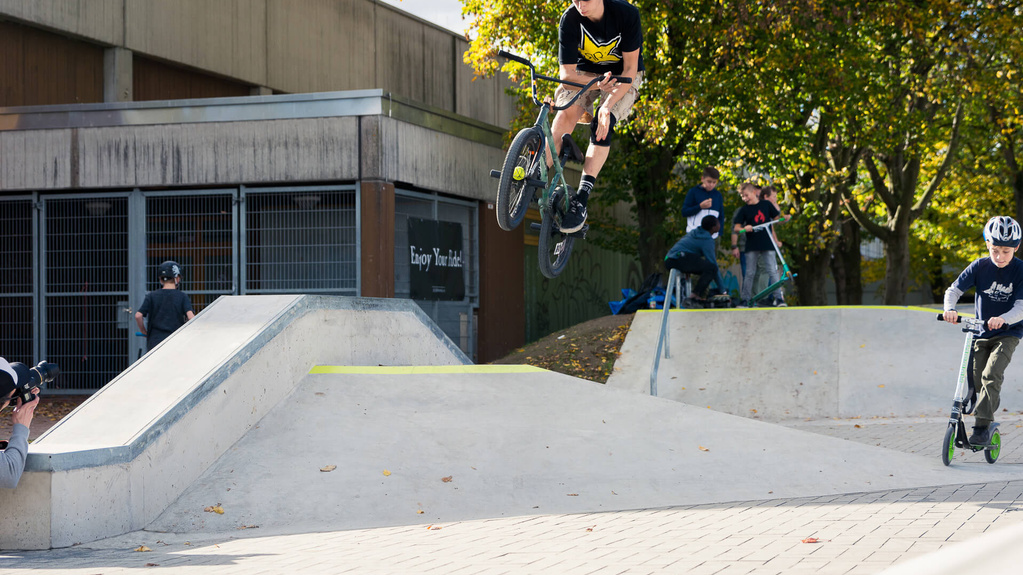 Several boys in skate park Hennef with bike and scooter