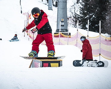 Snowboard kid slides on box