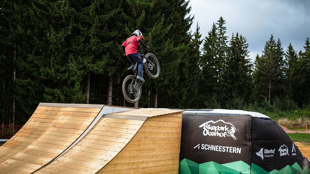 Biker jumps over wooden ramp onto airbag