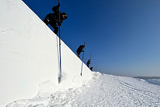 Mitarbeiter schaffen eine Mauer aus Schnee