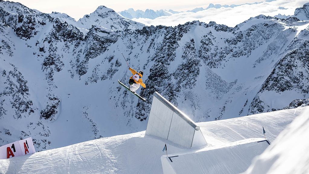 Skifahrer ist nach Sprung in der Luft vor Bergpanorama