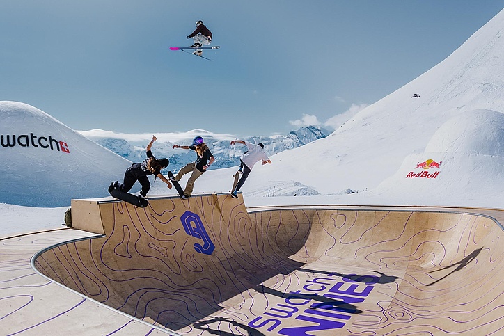 Rider bei spektakulären Tricks über einem Swatch Snowpark Bowl mit Holzrampenelementen am Schilthorn.