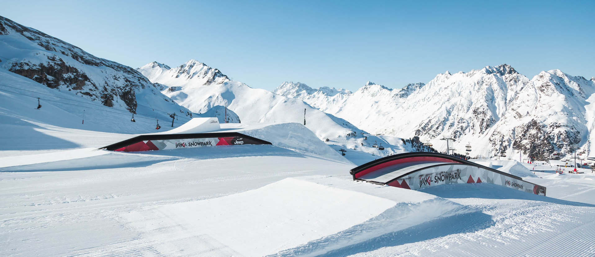 Obstacles im Snowpark Ischgl mit verschneitem Bergpanorama