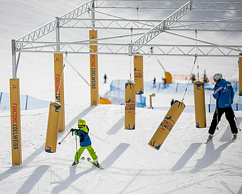 Kind und Erwachsener Skifahrer boxen gegen Säcke im Pendulum