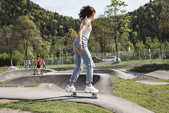 Skateboarder from behind in pump track Füssen